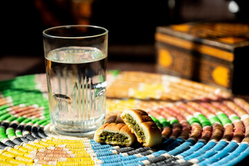Arabic sweets, maamoul and water on traditional background