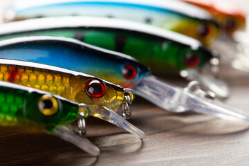 Fishing tackle - fishing spinning rod, hooks and lures on wooden background. Active hobby...