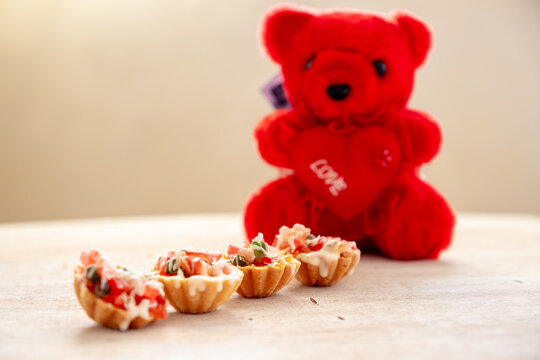 Teddy bear with valentine cupcakes and love with copy space