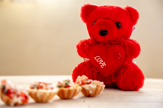 Teddy bear with valentine cupcakes and love with copy space