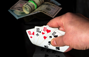 Poker cards with four of a kind or quads combination. Close up of a gambler hand is holding playing cards in casino