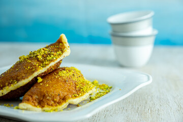 Ramadan sweets qatayef with white background and arabian coffee cups