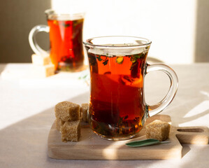 Black tea with sage herbs in a glass cup for drinking tea with friends on a sunny day. Space for text