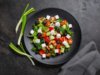 Greek salad on black plate 