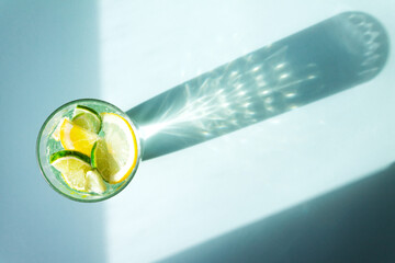 Glass glass with minimal water, lemon and lime slices. With a glass shadow effect. Space for text