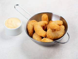 Deep fried shrimps in small pan with cheese sauce 