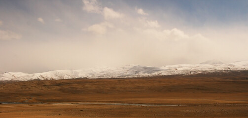 Pamir Highway in Gorno-Badakhshan Autonomous Region, Tajikistan. Deep Central Asia. Rocks, Blue Sly and Clouds. Untouched Nature in the Centre of Earth. Snow covered Pamir mountains.