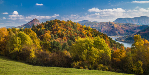 Landscape of colorful autumn forest on a sunny day with blue sky and river