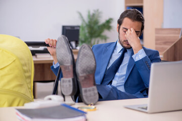 Young male employee looking after new born at workplace