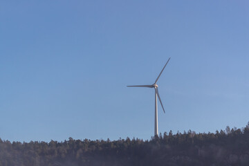 Wind turbine on woodland hill on hazy morning.Shot in Sweden, Scandinavia
