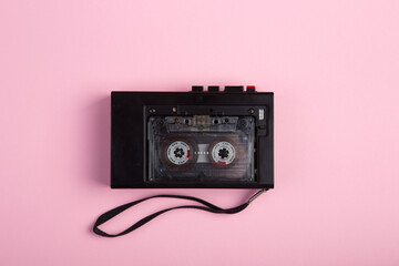 Music listening concept. Vintage cassette tape audio close-up on pink background, top view.