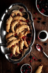Curd cookies with jam and berries on a dark wooden background
