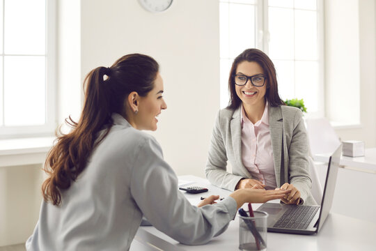 Happy Single Business Woman Meeting And Consulting Insurer, Bank Manager, Financial Advisor Or Loan Broker. Smiling Real Estate Agent Or Architect Talking To Client And Showing House Design On Laptop