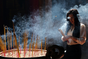 Obraz premium Chua On Lang taoist temple. Buddhist Worshipper. Burning incense sticks. Ho chi Minh City. Vietnam. 25.02.2017