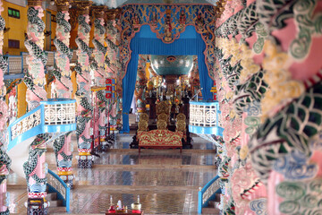 Interior of Cao Dai Great Temple with ornate dragon columns.  Thay Ninh. Vietnam.