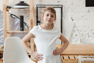 8-year-old girl in   white dress in   bright school interior