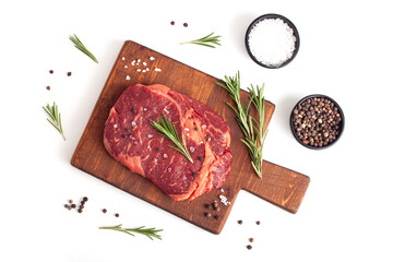 Raw rib eye steak of beef with rosemary isolated on white background