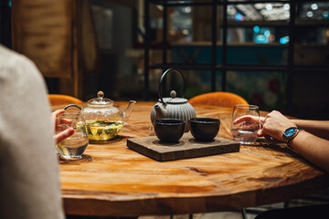 Selective focus shot of  people drinking hot tea on a wooden table, tea shop