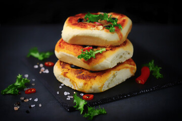 Delicious homemade mini pizzas on a black background. Mini pizzas in a column.