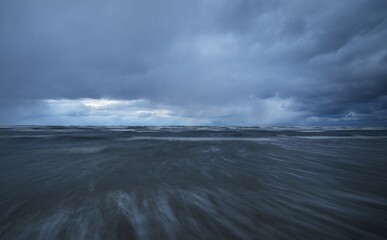 Dark storm sky above the Baltic sea, waves and water splashes. Dramatic cloudscape. Nature,...