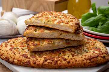 Tasty italian vegetarian food, fresh baked flat foccachia bread with white mozzarella cheese and herbs