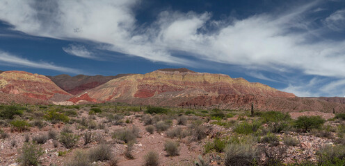 Colorful mountains and desert background. Panorama view of the sandstone and rock formations of yellow, red and orange minerals in the altiplano canyon, under a beautiful blue sky.