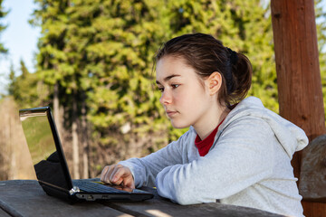 Girl using laptop outdoor
