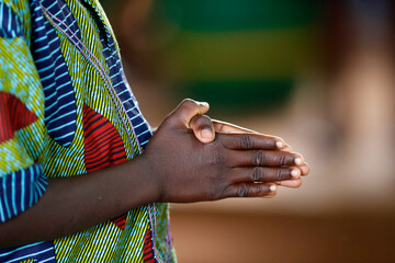 African church. Sunday catholic mass. Man praying. Close-up on hands.  Agbonou Koeroma. Togo. ...