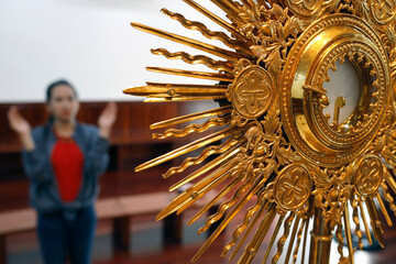 The Blessed Sacrament in a monstrance. Eucharist adoration.  Woman praying.  Thi Nghe Church.  Ho...