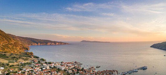 Aerial panoramic view of Komiza village coastline on Vis Island in Croatia sunset hour