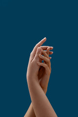 Close up of two female hands uniting with each other isolated on blue background