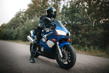 Fototapeta premium Black motorcycle driver in helmet and leather outfit