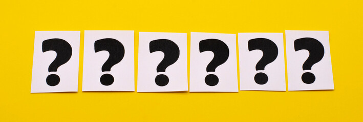 a question mark on a white sheet on a yellow background . FAQ frequency asked questions, Answer, Information and Brainstorming Concepts