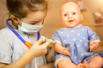A girl with a doll plays doctor, makes a syringe inoculation in the hand. Vaccination, vaccination...