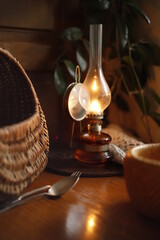 Lampa naftowa i kosz wiklinowy na stole bukowym © Seance_Photo_Sylwia