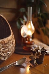 Lampa naftowa i kosz wiklinowy na stole bukowym © Seance_Photo_Sylwia