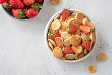 Tiny pancake cereal in a bowl with strawberry