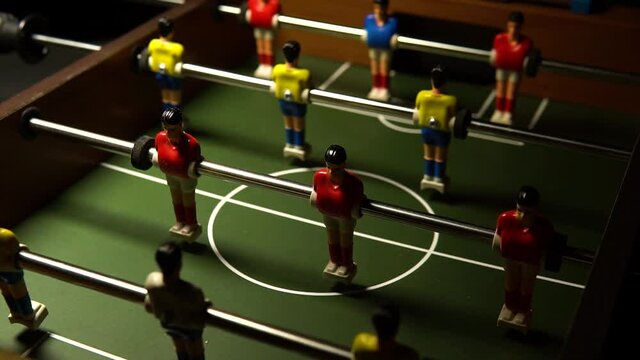 football on the table at night the light blinks goal, toy red white, EUR face. Competitive taca figurine table soccer miniature