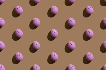 Easter banner. Seamless pattern. Conceptual art. Holiday stress. Sadness despair. Pink eggs with scared face painted ornament isolated on beige.