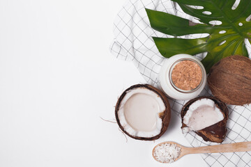 Coconut milk in glass bottle. Whole and cracked coco. Flat lay, top view isolated on white