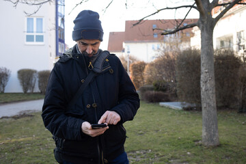 Alter Mann mit Smartphone ruft Nachrichten ab