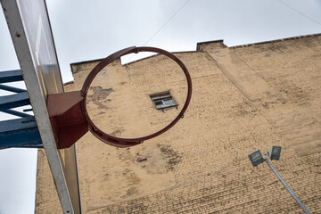 Basketball shield with a ring, on the background of a brick building