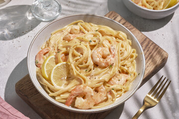 Italian pasta fettuccine in a creamy sauce with shrimp and tomato