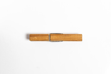 Wooden clothes peg on a white background surface. Top view