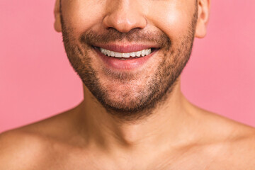 Obraz premium Detailed close-up image of young man smiling with perfect white teeth. Healthy concept isolated over pink background.