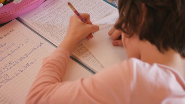 fille qui fait ses devoir pendant que le petit fr&egrave;re chante