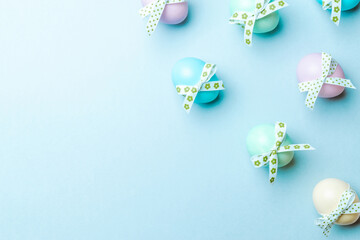Easter luxury. Colorful egg with tape ribbon on pastel blue background in Happy Easter decoration. Flat lay, top view.