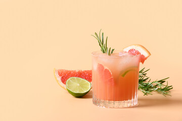 Grapefruit soda with lime garnish rosemary sprig on color beige background. Mocktail Paloma. Close...