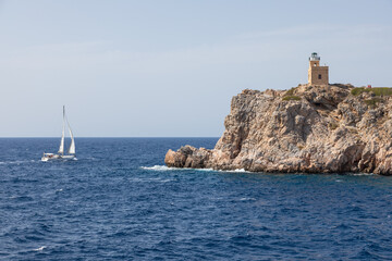 Fototapeta na wymiar Lighthouse on the rock in the background. Chora , Ios Island, Greece.