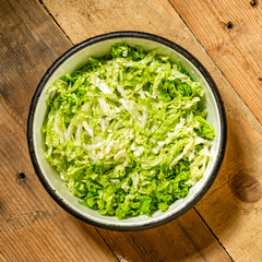 Finely chopped raw cabbage in a metal bowl